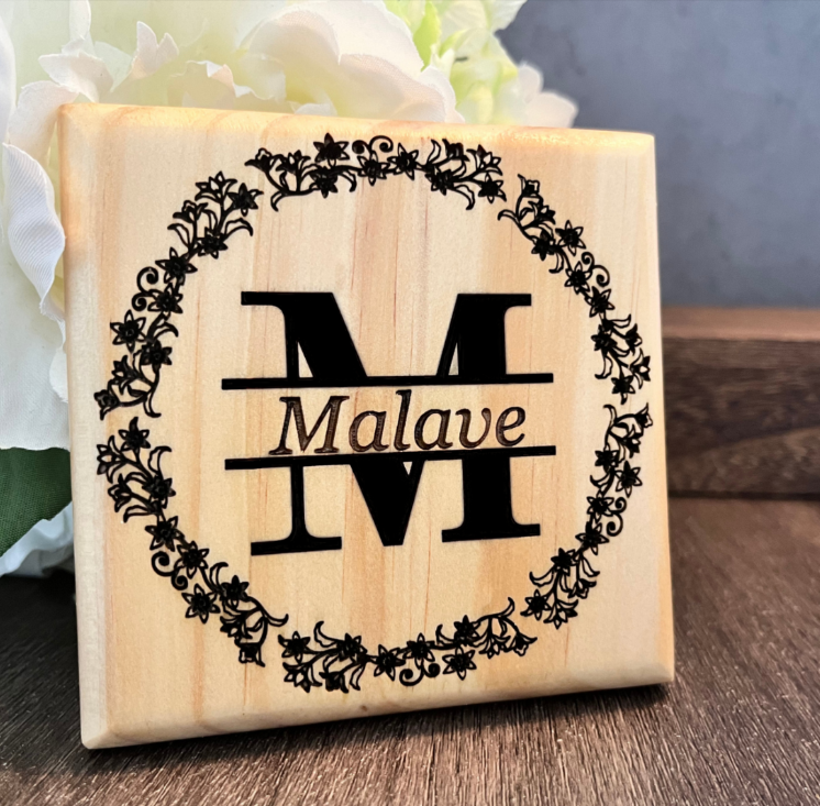 Deep engraved monogram 4x4 Wood Coaster product image. Personalized text fits within the split monogram and is surrounded by a floral wreath. 